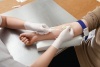 Odběr krve pacientovi s nitrilovými rukavicemi Peha-soft